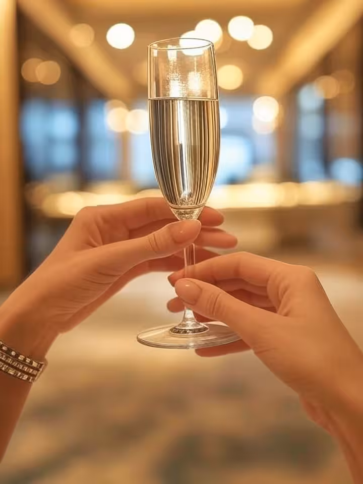 Close-up of elegant woman's hands holding champagne flute in luxury hotel lobby, designer bracelet v
